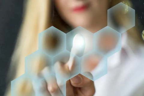 Person touching an hexagonal button on a digital interface Stock Photos