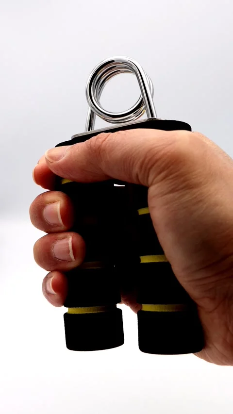 A person training their grip strength with a hand grip. Stock Footage 336520593