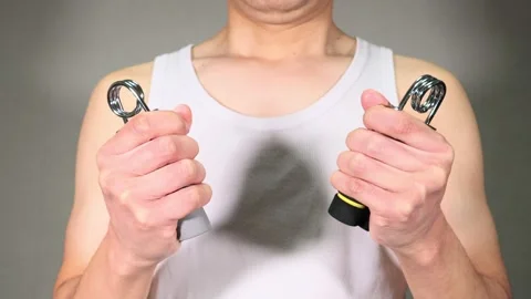 A person training their grip strength with a hand grip. Stock Footage 336674252