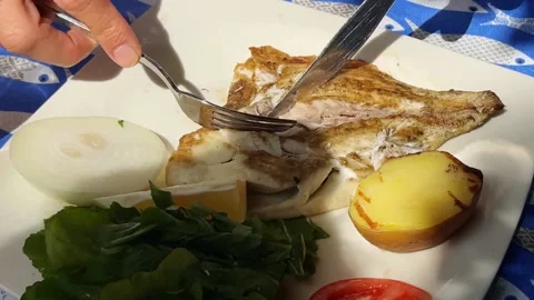 Person trying to clean fish bones in cooked fish . Video stock 239448006