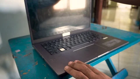 A person turning on a laptop computer on a desk, capturing the start of a w.. Stock Footage 340490075