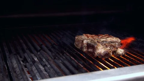 Person turning meat on grill Stock Footage 130057228