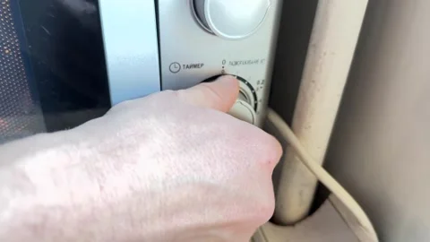Person turning microwave control knob close up at home, setting time or power Stock Footage 337104501