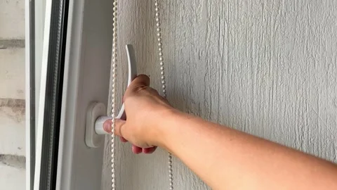 Person turning a window handle to lock it for energy saving concept Stock Footage 338186421
