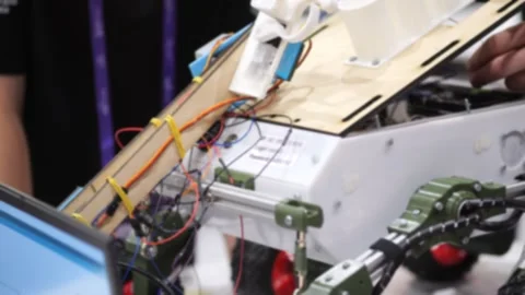 Person tweaks robotic device with exposed circuitry and moving parts Stock Footage 345024519