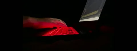 Person type on laptop technology keyboard with red backlight. Coding, light,  Stock Footage 219942059
