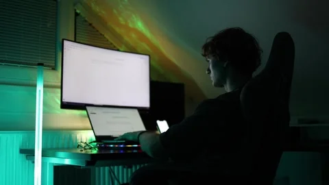 Person types on keyboard in low light workstation glowing reflections from monit Stock Footage 316878197