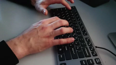 A person types on a keyboard with two hands Stock Footage 152083356
