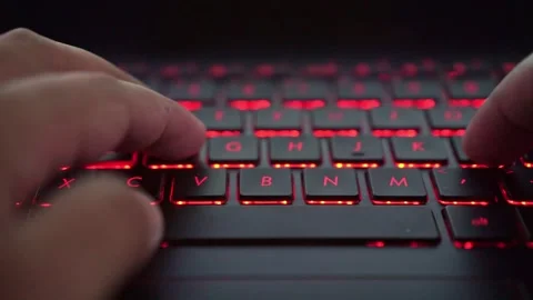 Person typing on backlit keyboard, close-up, digital workspace, technology, and Stock Footage 334395771
