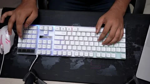 Person typing on a backlit mechanical keyboard with a world map mouse pad Stock Footage 317737295
