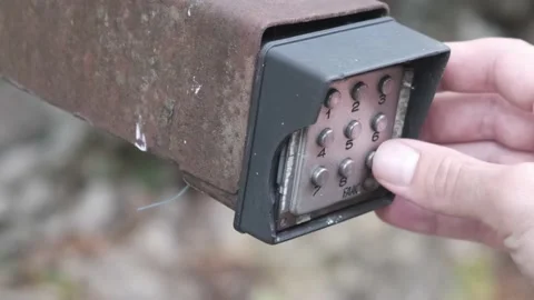 Person typing in a code to open a gate using buttons digital input pad Video stock 140043799