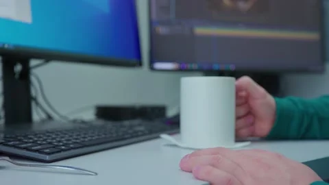 A person is typing on a computer and taking a sip from a white mug Stock Footage 271064301
