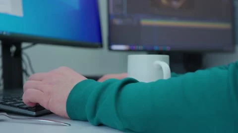 A person is typing on a computer with a cup of coffee next to them Stock Footage 270956490