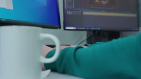 A person is typing on a computer with a cup of coffee Stock Footage 271181209