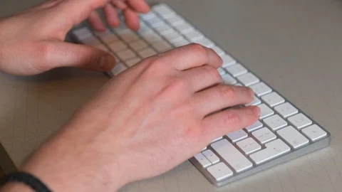 Person typing on a computer keyboard at a desk Vídeo Stock 124097897