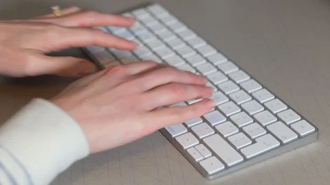 Person typing on a computer keyboard at a desk Vídeo Stock 124098476