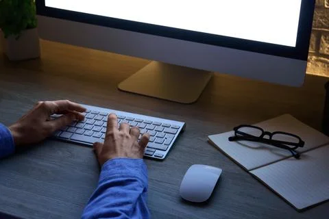 Person typing on computer keyboard at night, remote work and online business, Stock Photos