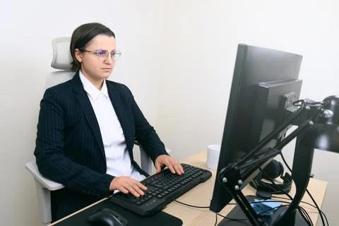 Person typing at desk using desktop computer in office 库存照片