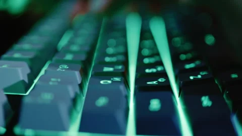 Person typing on green backlit gaming keyboard Stock Footage 341658657