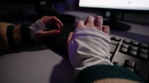 Person typing on keyboard at computer desk at night 動画素材 348029539