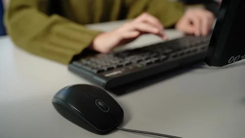 Person typing on keyboard at desk with computer mouse Video stock 348029552