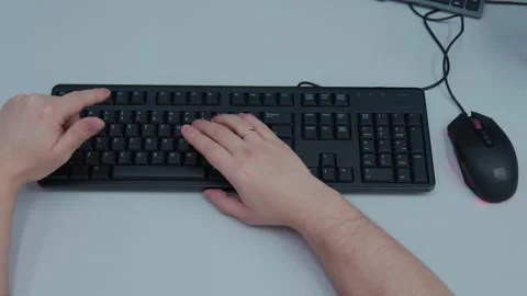 A person is typing on a keyboard with a mouse in front of them Stock Footage 277695034