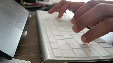 A person typing on a keyboard while working on laptop. Indian software engineer  Stock Footage 246043482