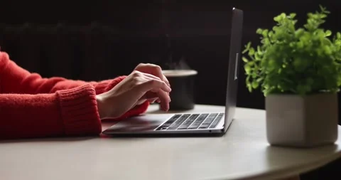 Person typing on laptop and drinking hot beverage in cozy home office setting Stock Footage 339072604