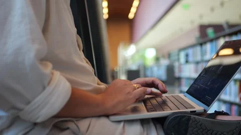 Person Typing on Laptop in Library, Close-Up of Modern Workspace for Coding... Vídeo Stock 334436971