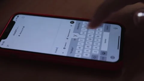 Person typing a query in ChatGPT on a smartphone with a red case Stock Footage 304068092