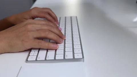 A person typing a white keyboard Stock Footage 141890225