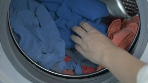 Person unloading and loading clean cloth after doing cleaning laundry in machine Stock Footage 336563751