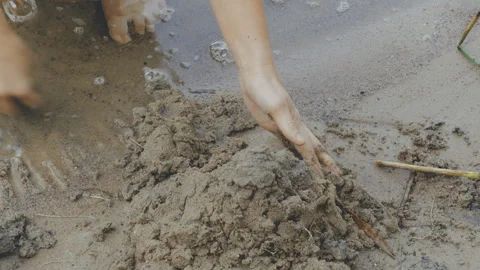 Person with an unrecognizable face builds a castle from wet seaside sand Video stock 310659098