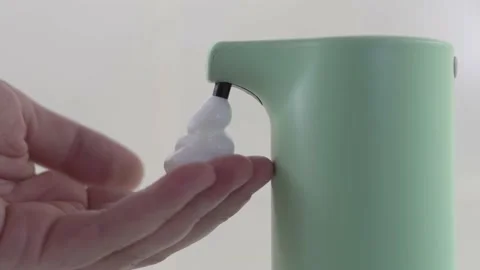 A person uses an automatic soap dispenser in the bathroom. Close up Stock Footage 194015482