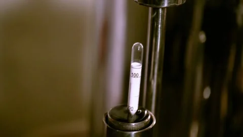 A person uses a device to measure the level of alcohol in a drink. Stock Footage 165170599