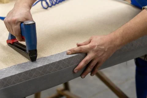 A person uses a pneumatic stapler Фото
