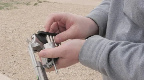 Person Uses Speedloader to Load Bullets into a Revolver Stock Footage 60692461