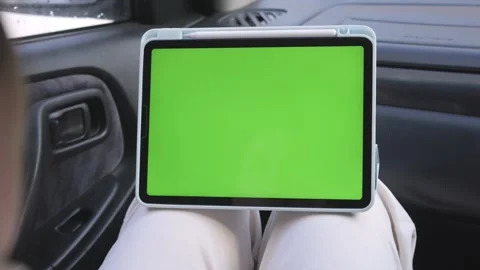 Person uses tablet with green screen while seated in vehicle Stock Footage 341177202