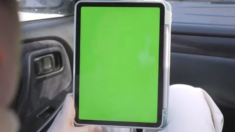 Person uses tablet inside vehicle, green screen active Stock Footage 343586590