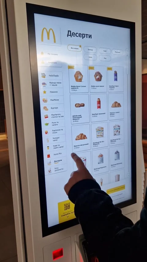 A person uses the touchscreen of a McDonald's self-service kiosk in Ukraine. 動画素材 332597890