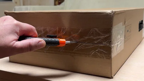 Person Uses Utility Knife to Cut Packing Tape on Cardboard Box Stock Footage 329455852