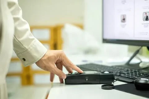 Person using a barcode scanner at a desk with computer Фото
