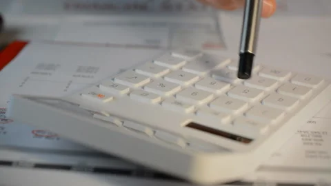 Person using a basic standard white calculator to create financial reports Video stock 166058329