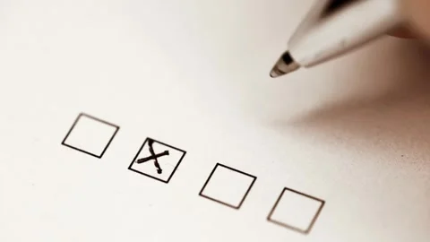 Person using black pen to draw X marks inside checkboxes on paper document Stock Footage 304985377