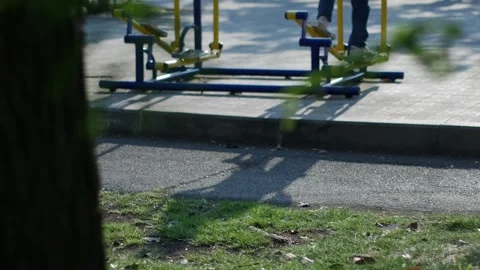 Person using blue and yellow outdoor elliptical exercise machine Stock Footage 332293349