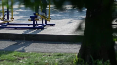 Person using blue and yellow outdoor elliptical exercise machine 库存影片 335069244