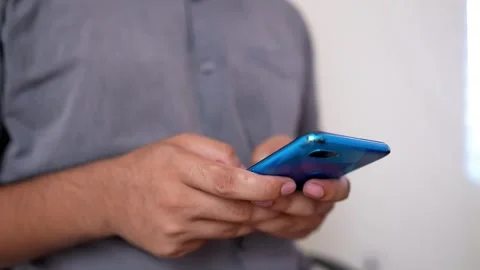 Person using a blue smartphone, close-up of hands Stock Footage 315981292