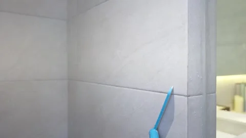 Person Using Blue Squeegee to Clean Glass Shower Door in Bathroom Stock Footage 335612373