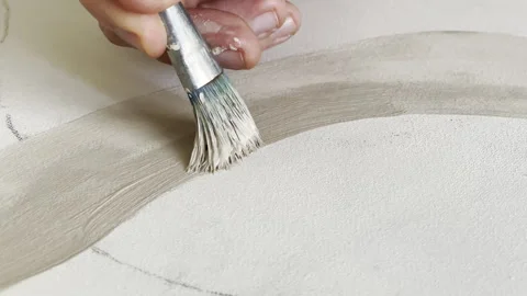 Person using brush to paint natural lines with beige oil paint on canvas, drawn Stock Footage 302196811