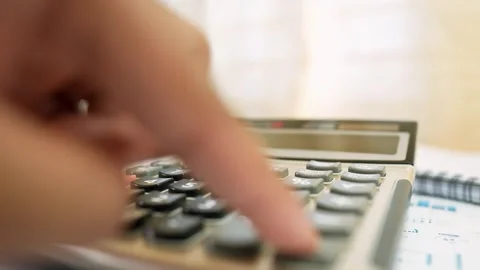 Person Using Calculator on Desk, Close-up of a person using a calculator on.. Stock Footage 317736901